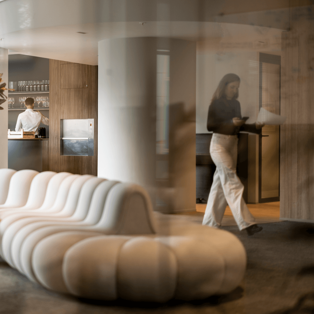 moderne loungehoek met witte bank en collega’s in achtergrond hvk stevens