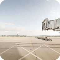Empty airport runway with boarding bridge under clear sky
