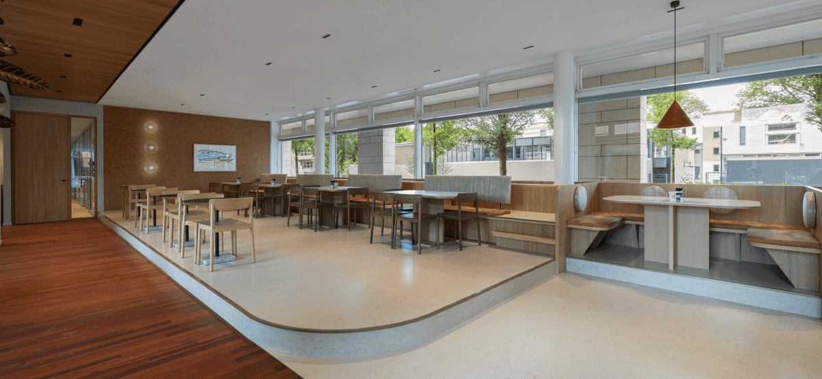 Bedrijfsrestaurant met houten vloer en meerdere tafels