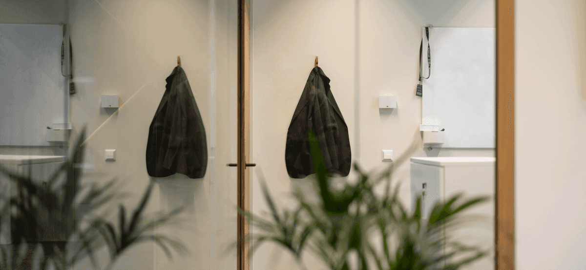 Black blazer on coat hook in minimalist office interior