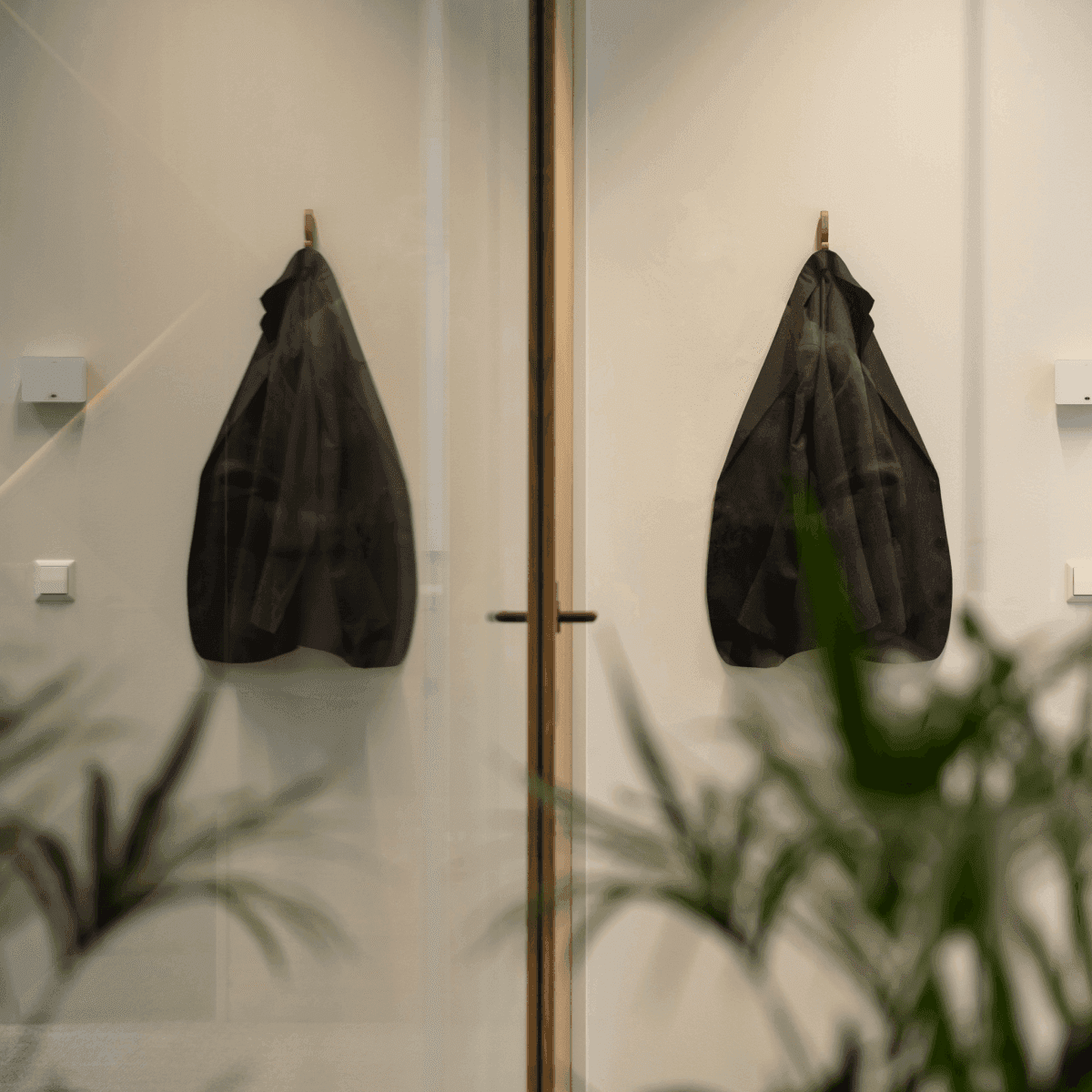 Black blazer on coat hook in minimalist office interior