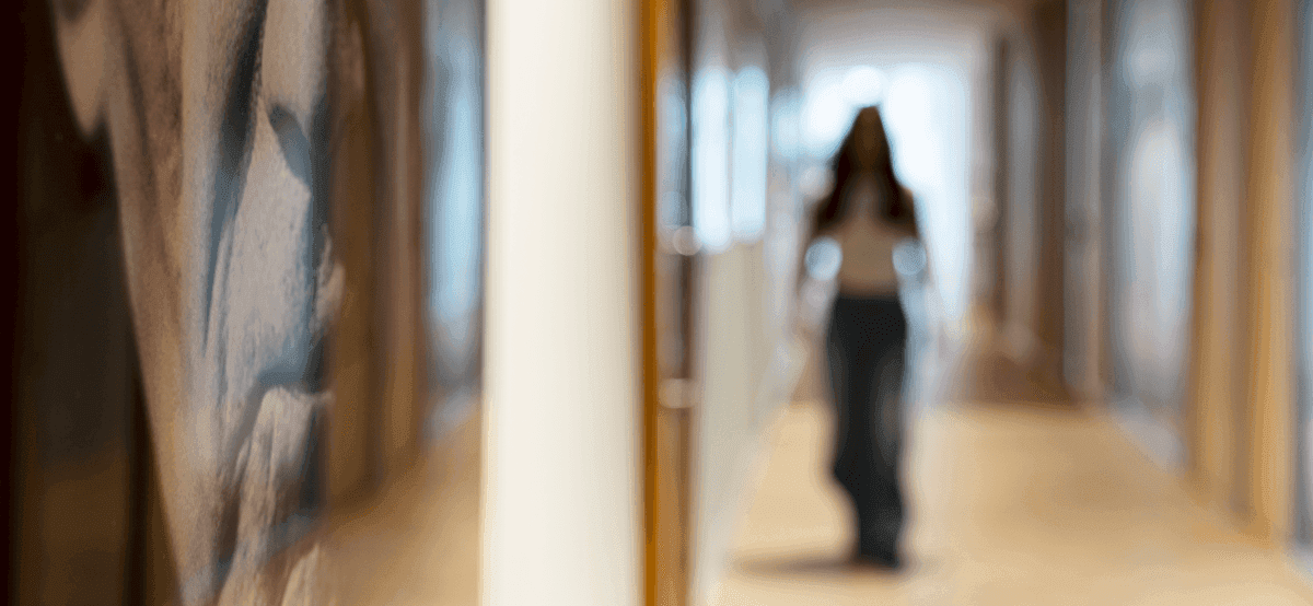 Blurred photo of woman walking through office hallway