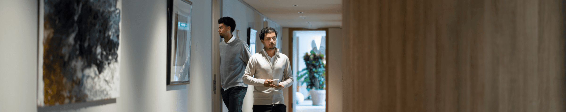 Employees in hallway with abstract art on wall