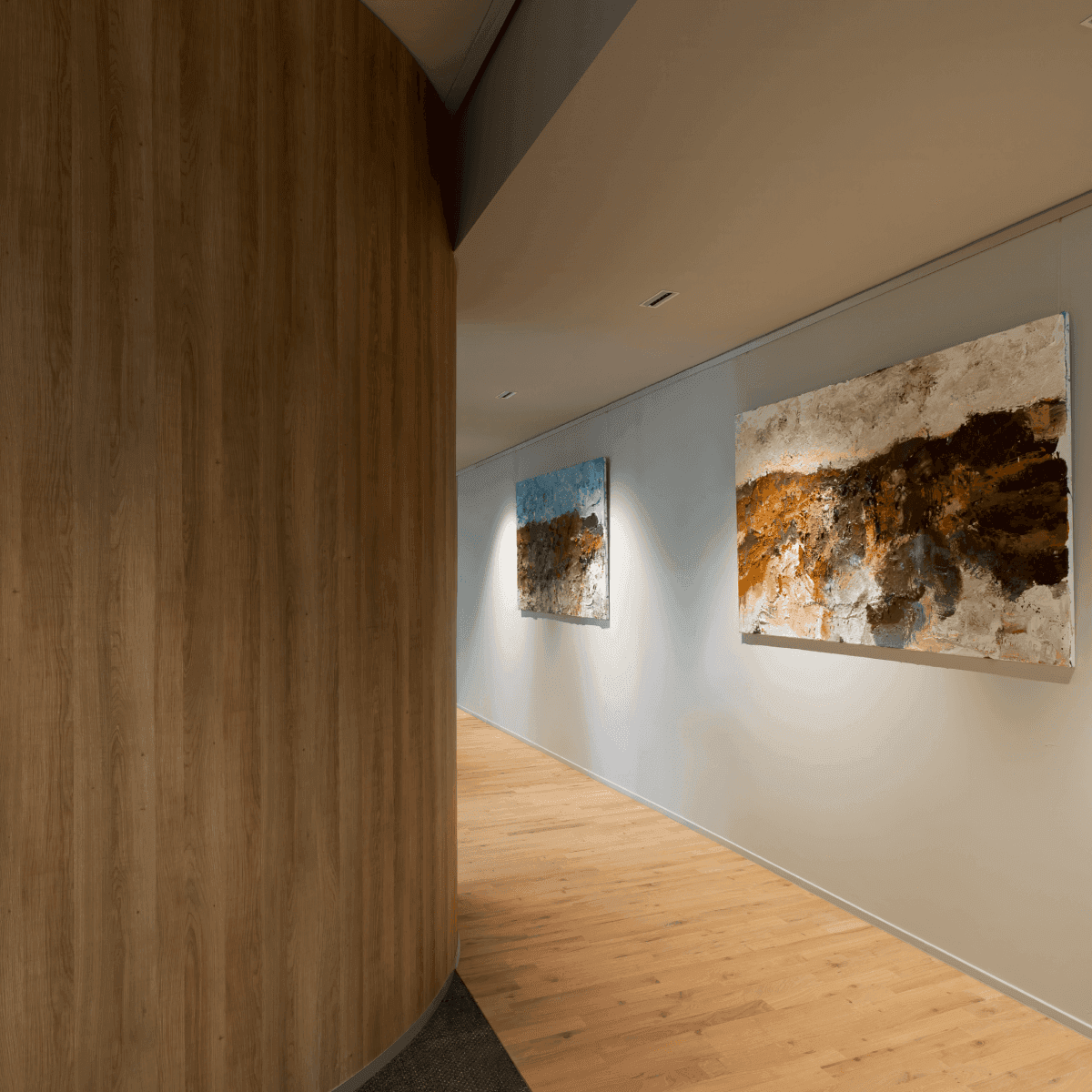 Gang met houten vloer en twee kunstschilderijen