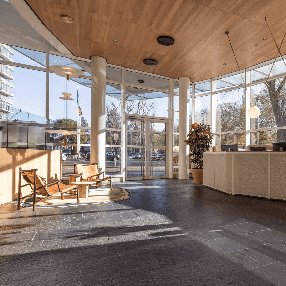Modern reception with large windows and wooden chairs