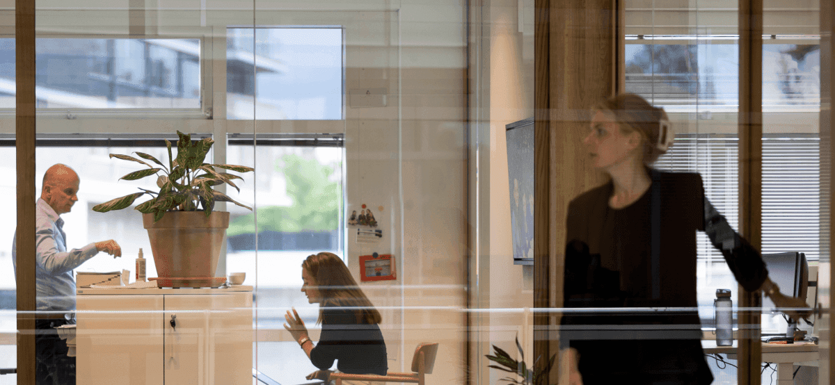 Office interior with colleagues in discussion through glass wall