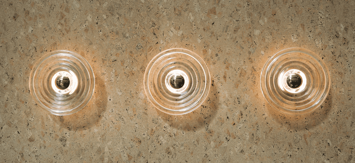 Round modern wall lamp with light reflections on cork