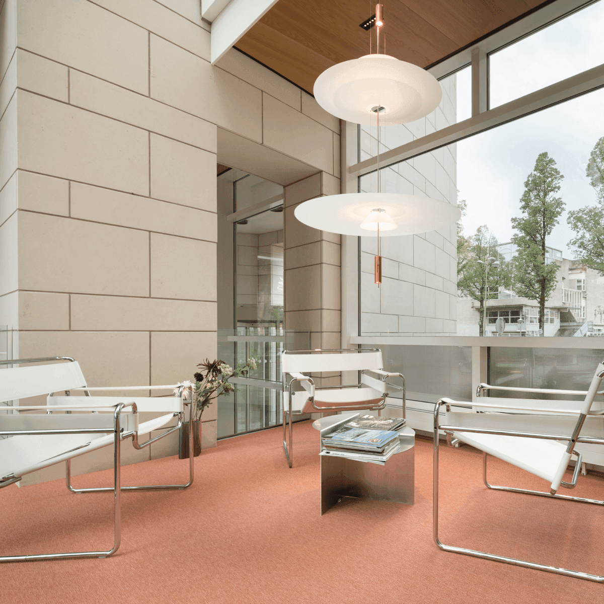 Seating area with white chairs and orange floor in office space