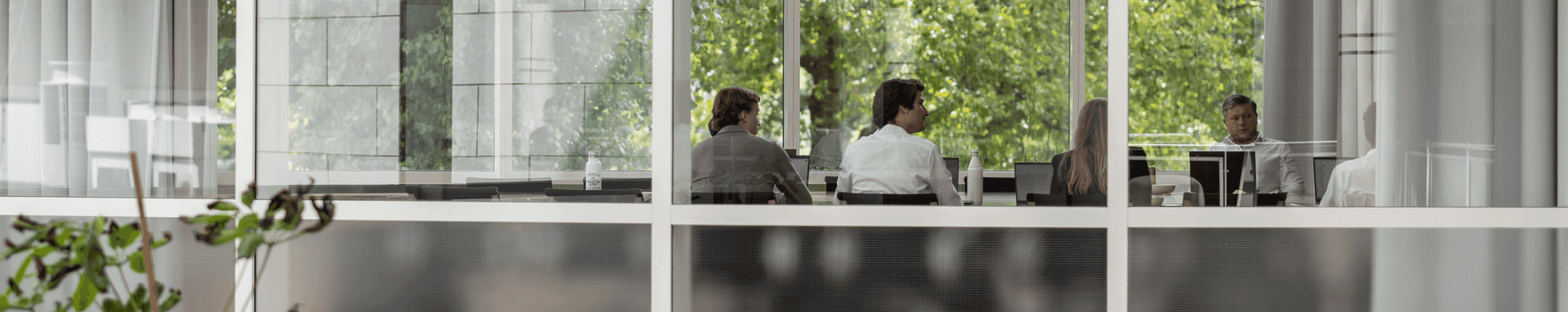 Vergaderruimte met grote raampartijen en groen uitzicht