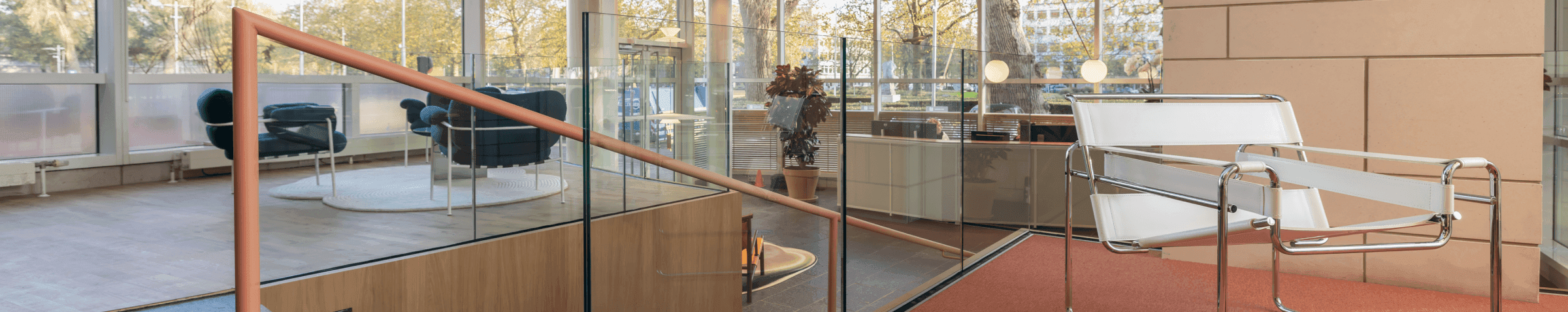 White design chair on orange carpet in modern lounge corner