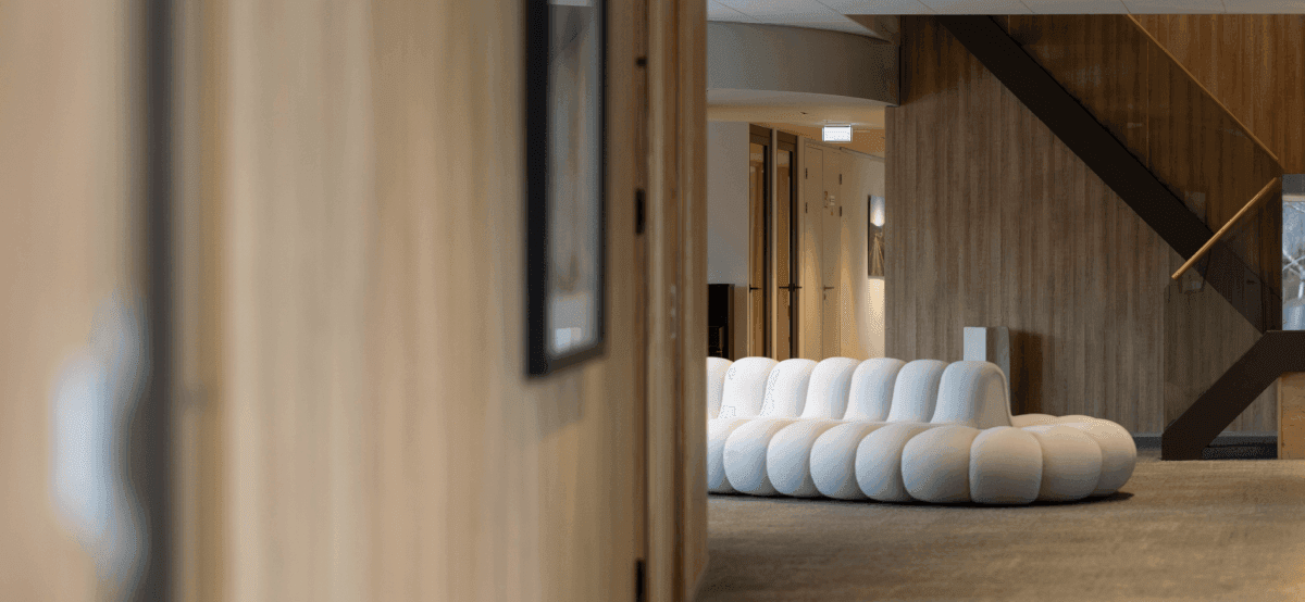 White designer sofa in modern office hall with staircase