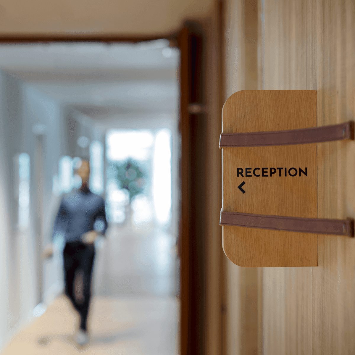 Wooden sign with reception text in hallway