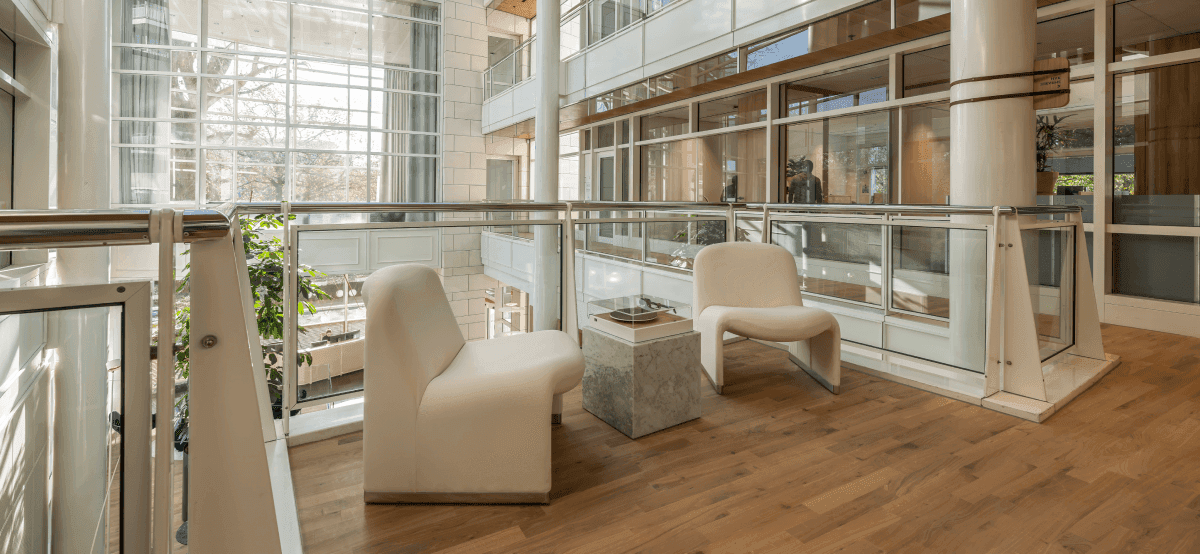 Zitruimte met twee witte stoelen en glazen balustrade